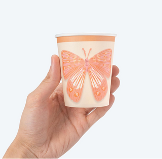 9oz paper cup, white with orange butterfly print on front, held in a hand