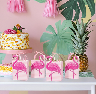 Four pink flamingo gift bags on display with striped pattern and ribbon handles