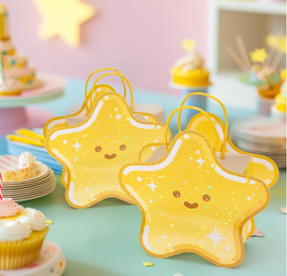 Star-shaped yellow gift bags with loop handles, arranged on a pastel table