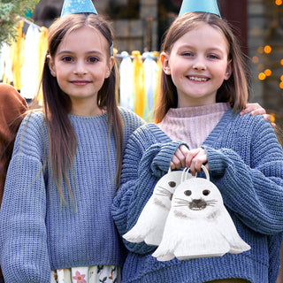 White seal face gift bags with handles, held by two kids
