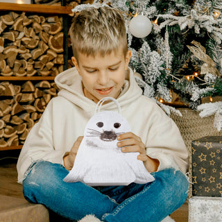 White seal face gift bag with handle, held in children’s hands