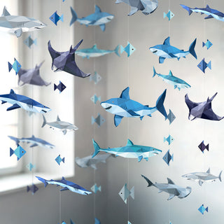 Shark party garland with assorted blue and gray paper sharks hanging overhead