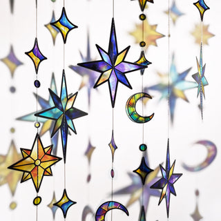 Close-up star and crescent moon hanging garland with iridescent plastic ornaments