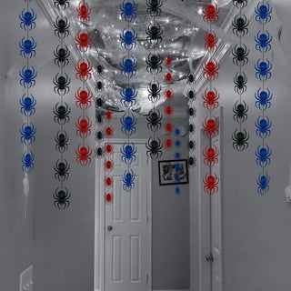 Spider garland draped over doorway and wall, repeating red, blue, and black spiders