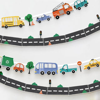 Transportation-themed classroom banner with curved road, buses, trucks, cars, and trees