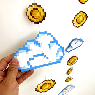 Handheld pixel garland section with blue cloud cutouts and gold coin disks