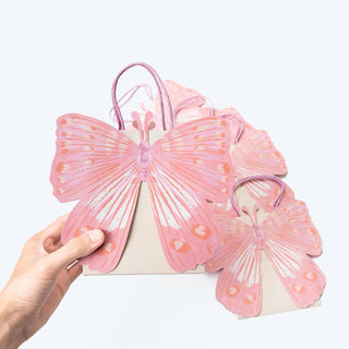Pink butterfly-shaped gift bag with curved handle, close-up with two bags
