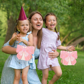 Pink butterfly-shaped gift bag with handle, held by children