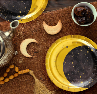 Gold metallic star and moon paper party plates for celestial birthday party decorations above side