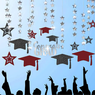 Graduation cap and star banner garland with hanging burgundy caps, dark mortarboards, silver stars
