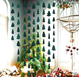 Dark green Christmas tree garland hanging in window, tree cutouts on string