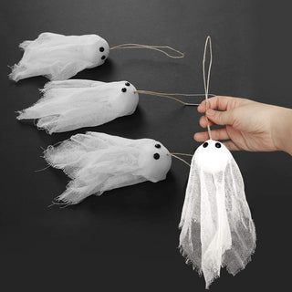 Hanging ghost decoration with white tulle sheet body and black eyes, held by hand