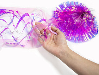Close-up of hanging iridescent purple jellyfish bell with hand holding ribbon strands