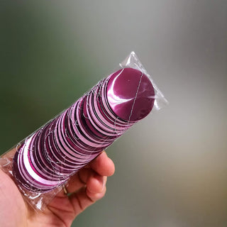 Maroon and pink striped paper party favor cylinder in plastic wrap