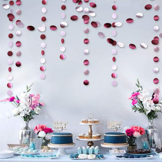 Pink and maroon circle dot hanging garlands creating a party backdrop