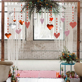 Heart garland hanging from an arch with glitter hearts in pink, red, and silver