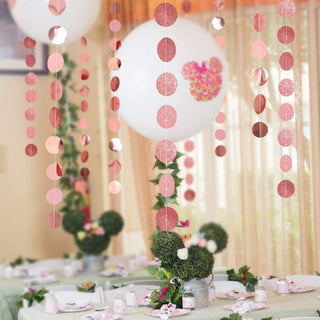 Rose gold and pink circle dot garland kit hanging from ceiling with round glitter discs