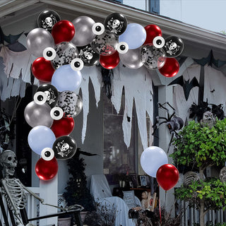 Outdoor Halloween balloon arch with red, silver, black, and light blue balloons and skull prints