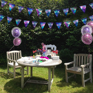 Galaxy starry triangle bunting banner with purple and teal printed flags overhead.